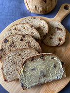 Cinnamon and date loaf, sliced and buttered on a wooden board